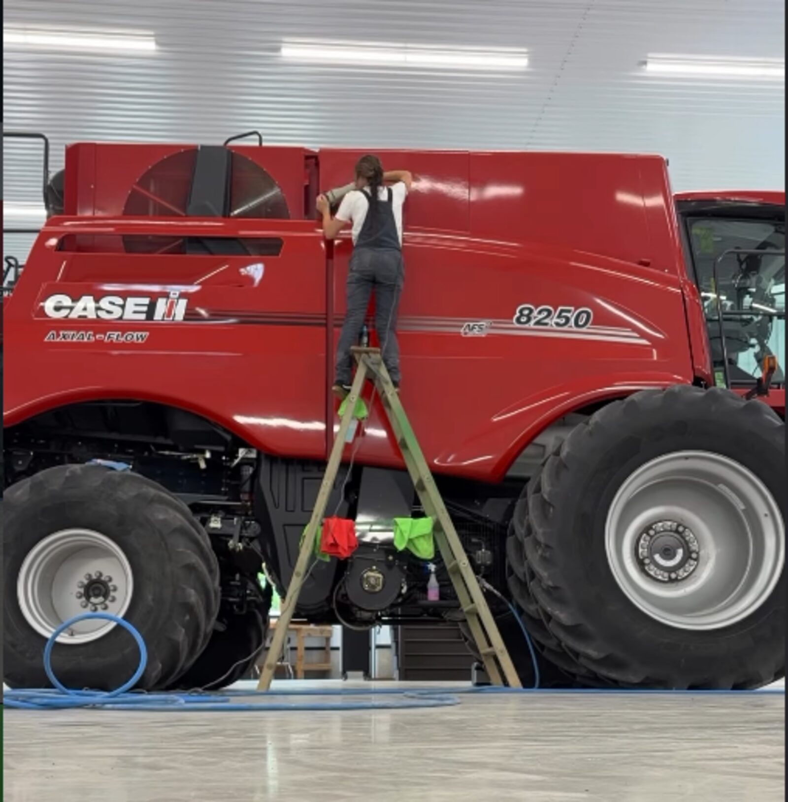 Jody detailing farm equipment from a ladder