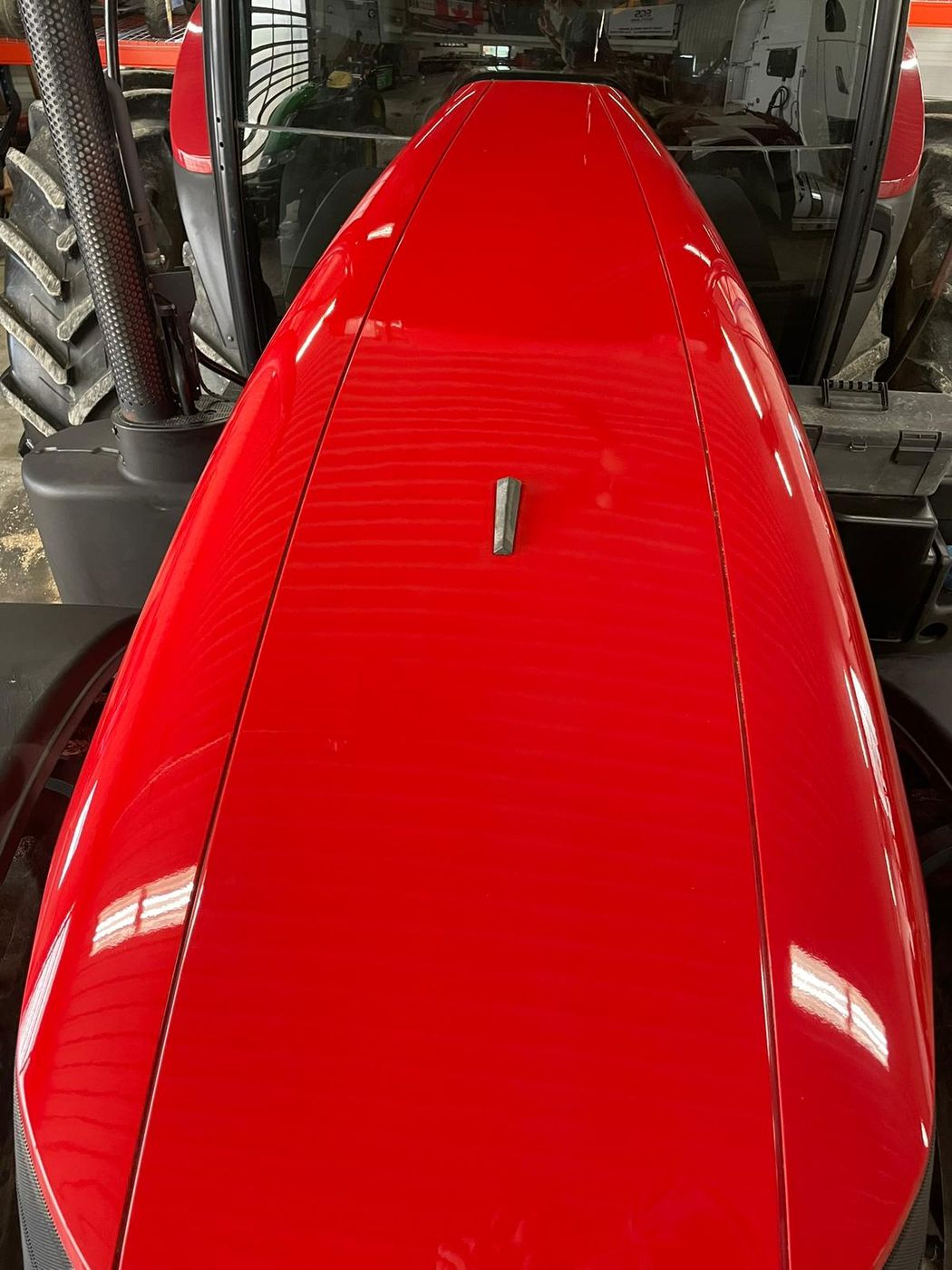 Red tractor hood after polishing, deep mirror gloss