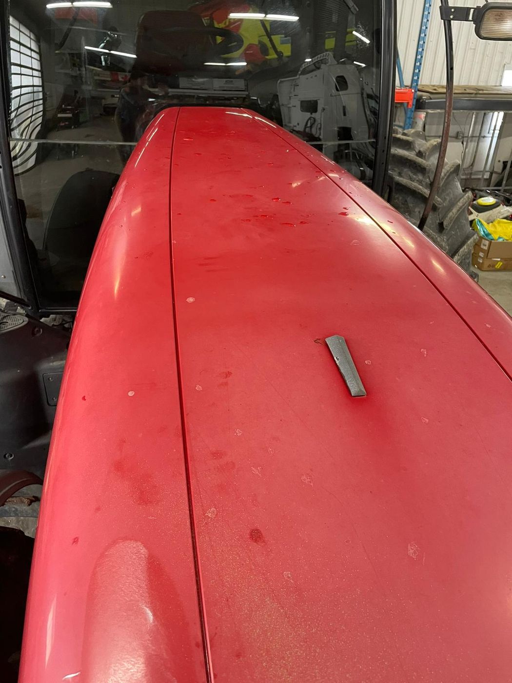 Red tractor hood before polishing, dull faded paint